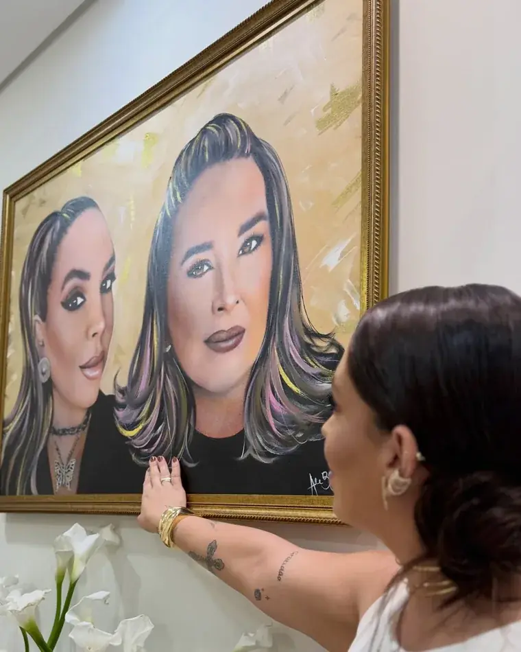 Retrato in memoriam pintado por Ale Baggio, cliente diante da tela emoldurada