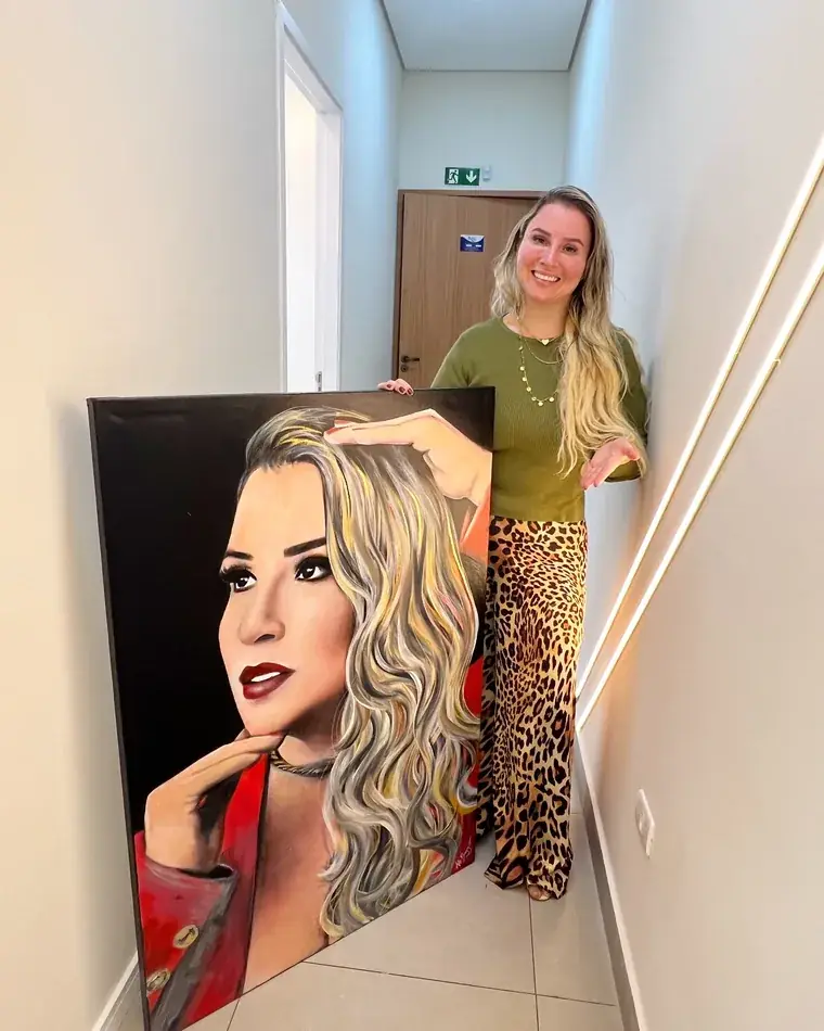 Cliente segurando o retrato dela pintado por Ale Baggio